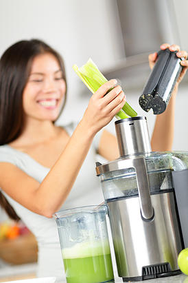 Vegetable juice - woman juicing green vegetables